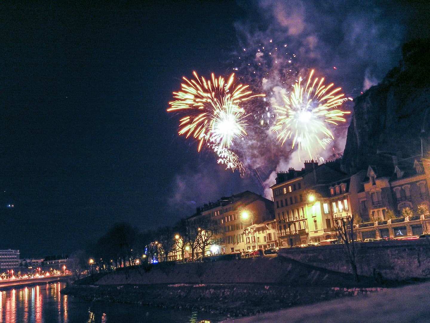 Fireworks seen from the bridge over the river “Isère” in Grenoble, France