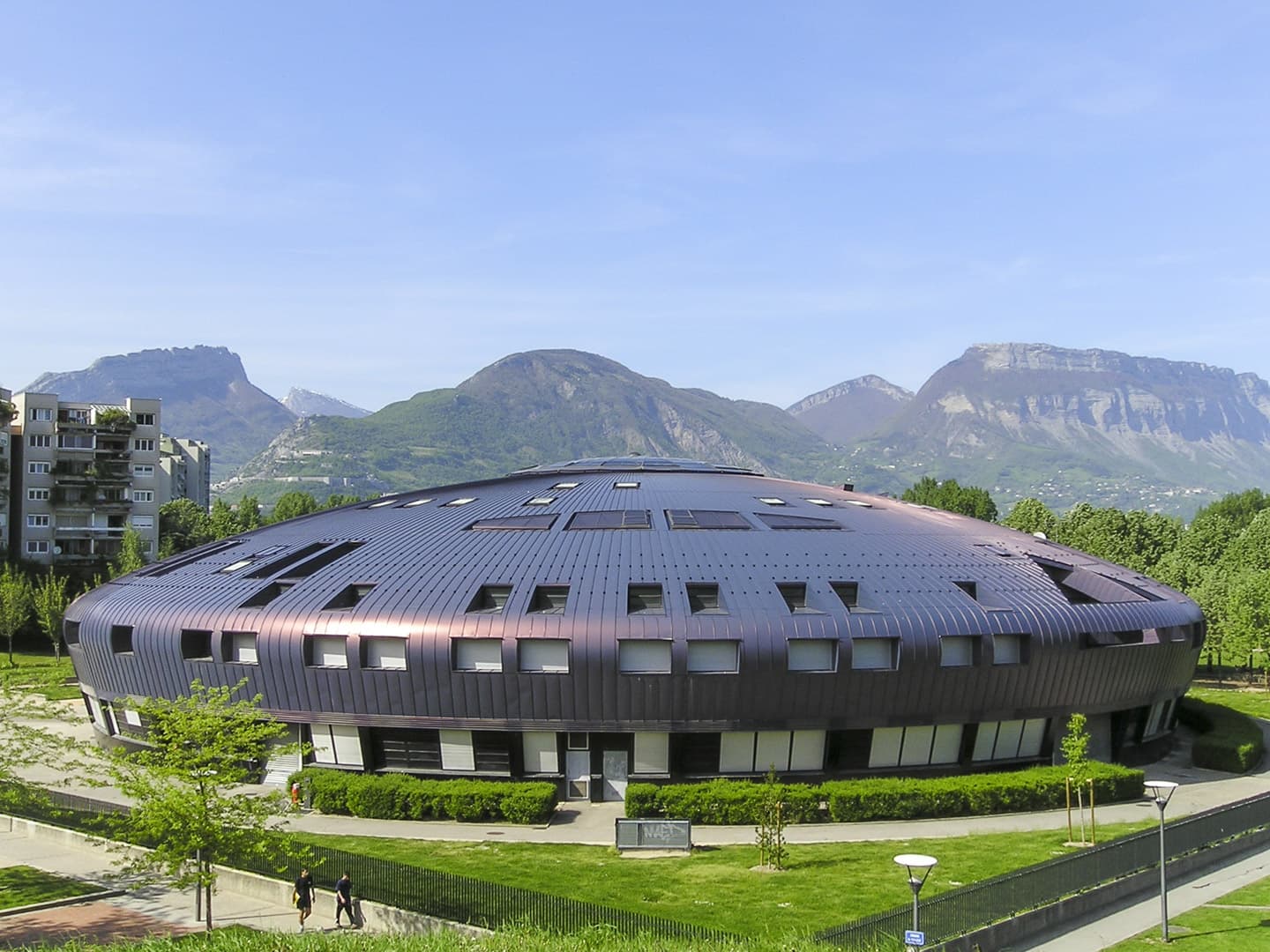 UFO like “Lucie Aubrac” Middle School building in Grenoble (France) with the Alps in the background