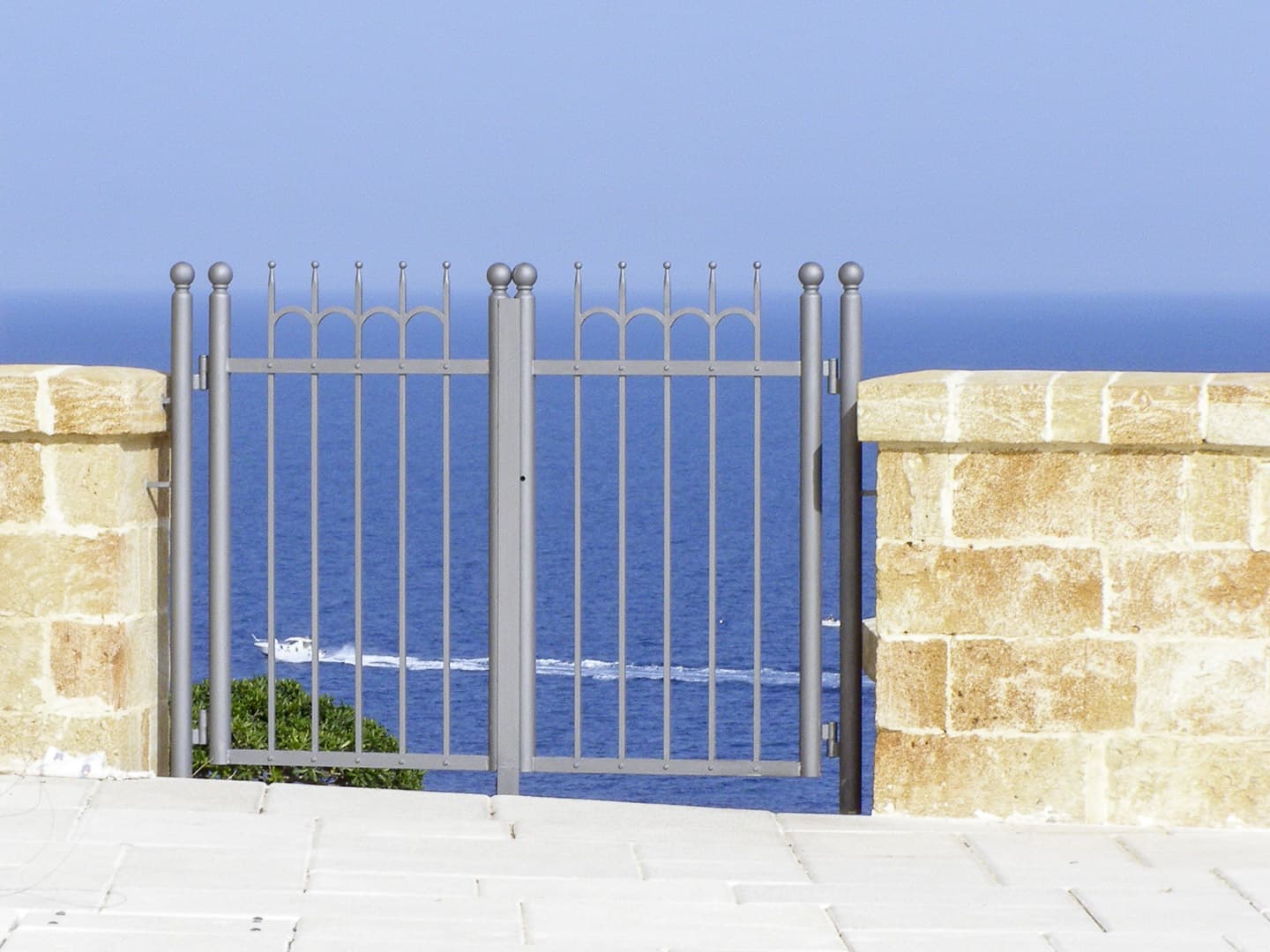 A gate with the sea in the background in Santa Maria di Leuca