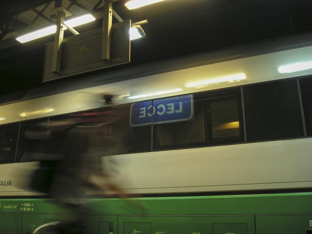 The sign of the train station of Lecce, reflected in the train window