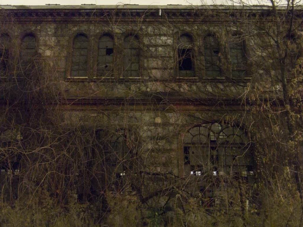 Facade Covered with Plants at the Abandoned Train Repairing Workshop in Turin, Italy